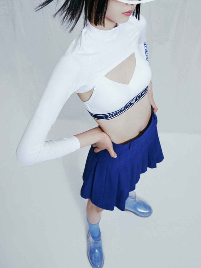 투명 썬캡을 쓰고 긴팔 크롭티, 언더웨어 탑, 파란 테니스스커트, 목이 긴 파란양말, 투명부츠를 신고 허리에 손을 올린 여자